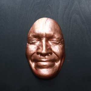 Copper effect Smile on black background, wooden base 30x30cms